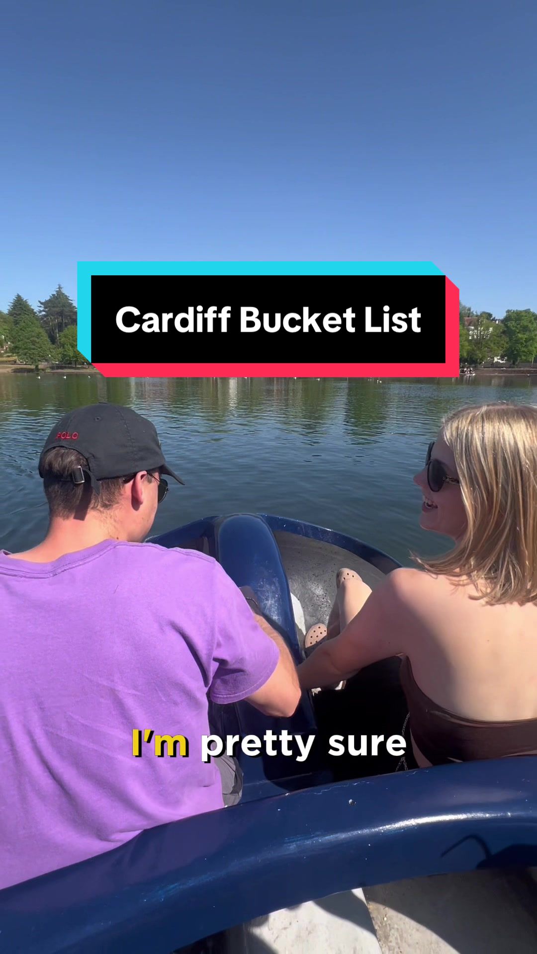Two young people operate a pedal boat on a sunny day