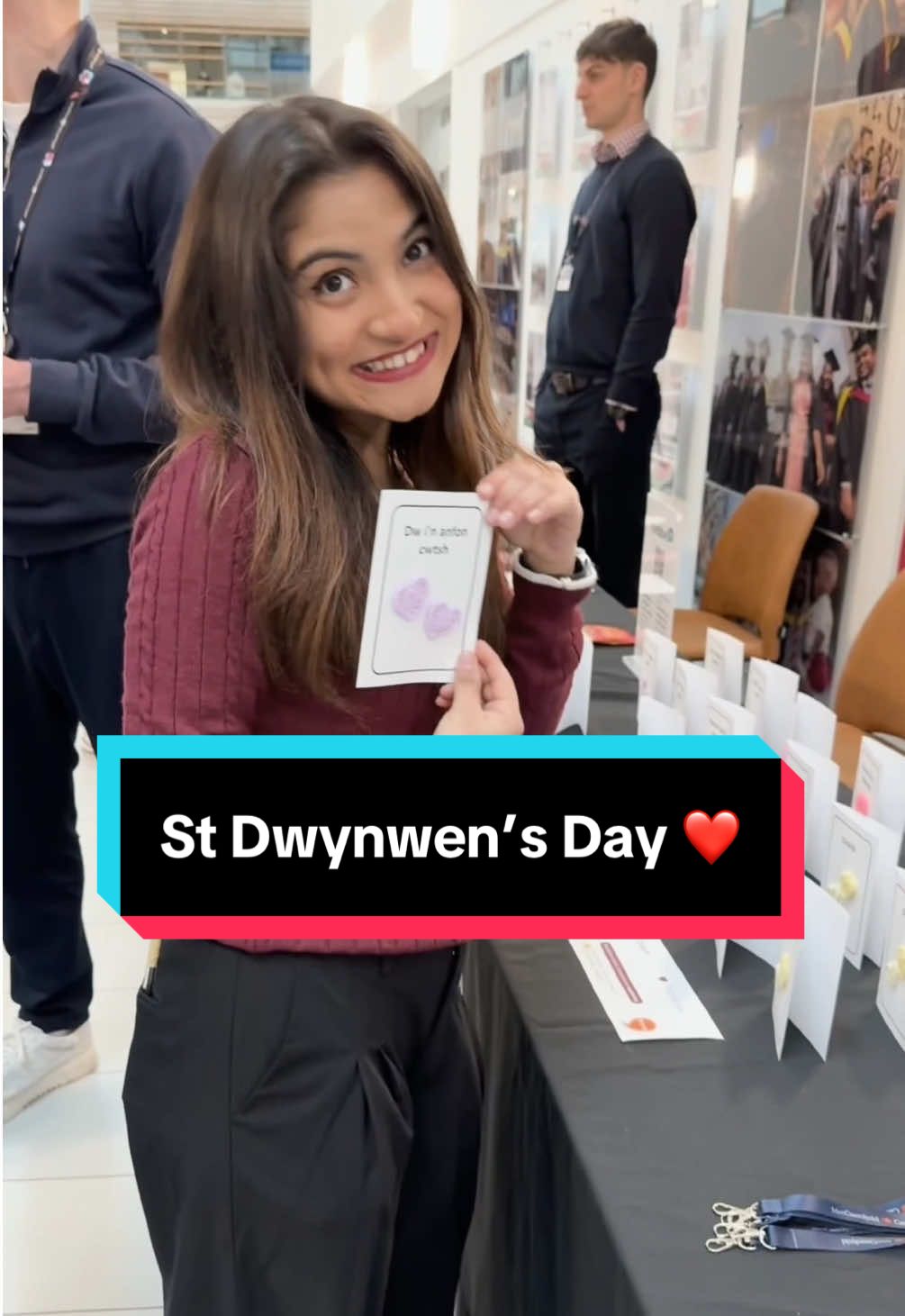 A young woman holds a small detailed card